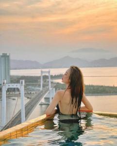 a woman is sitting in a bath tub in the water at GOLDEN BAY APARTMENT With SEA VIEW - Đà Nẵng in Da Nang