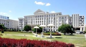 a large white building with umbrellas in a park at Datong Hotel in Datong