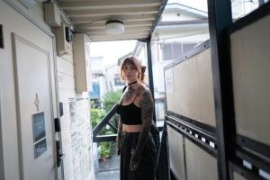 a woman with a tattoo on her arm standing in a hallway at Kaku Studio Apartment Ikebukuro in Tokyo +27 photos