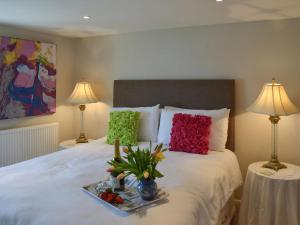 un letto con due lampade e un vassoio di frutta sopra di Samphire Cottage a Brixham