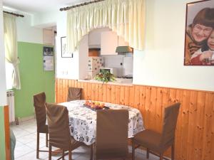 a dining room with a table and chairs and a kitchen at Comfortable holiday home only 500m to the sea with outdoor kitchen, wifi and airco in Banjole