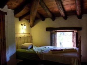 a bedroom with a bed in a room with a window at Charming Stone Houses at Molino in Alájar +32 photos