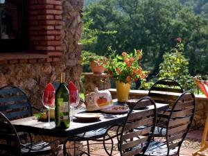 a table with wine bottles and chairs on a patio at Charming Stone Houses at Molino in Alájar