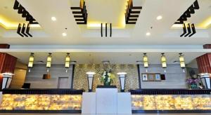 a lobby of a hotel with a counter and stairs at Excemon Yuyao Hemudu Hotel in Ningbo