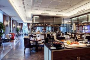 a restaurant with tables and chairs and a buffet at The Qube Hotel Nanchang East in Nanchang