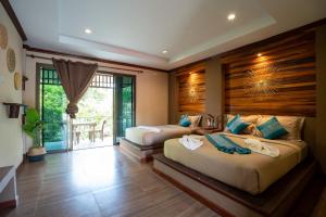 una camera da letto con due letti e una grande finestra di Lanta Riviera Beach Resort a Ko Lanta Altre 183 foto