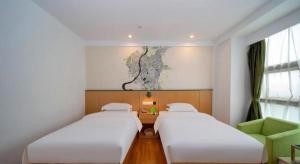 a room with two beds and a chair in it at Vatica Hefei Feidong County Yuzhou Central Square Hotel in Hefei +241 photos