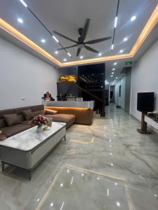 Una sala de estar con un sofá y un ventilador de techo. en Tam Cốc Phương Thảo Homestay, en Ninh Binh