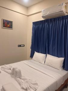 1 dormitorio con 1 cama con cortina azul en Vallimony Luxury Stays, en Trivandrum 5 fotos más