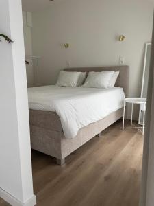 a bed with white sheets and pillows in a bedroom at Bright apartment with private parking near Ghent city centre in Ghent