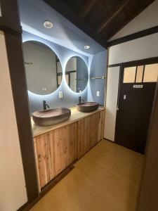 two sinks in a bathroom with two mirrors at yumigahama Eaglehouse in Minamiizu +65 photos
