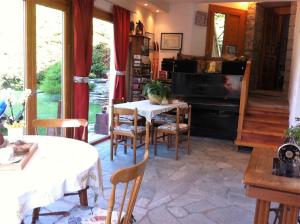 a dining room with a table and a piano at Le Lierre in Châtillon
