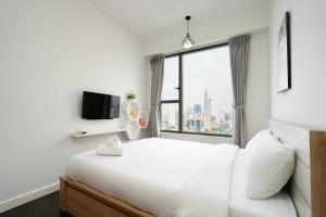 a bedroom with a white bed and a window at Rivergate Residence Central in Ho Chi Minh City +32 photos