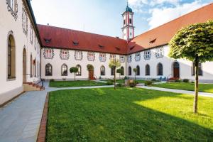 a courtyard of a building with a clock tower at KurOase im Kloster in Bad Wörishofen