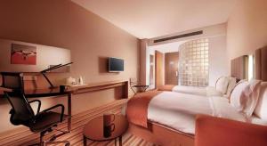 a hotel room with a large bed and a chair at Holiday Inn Express Yangzhou City Center By IHG in Yangzhou