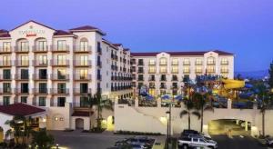 a large hotel with cars parked in a parking lot at Courtyard by Marriott Anaheim Theme Park Entrance in Anaheim