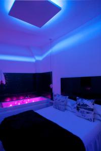 a bedroom with a bed with purple lights on it at Hostal Santo Domingo in Madrid