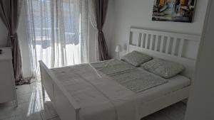 a white bed in a room with a window at Apartment 211 in Neoi Epivates