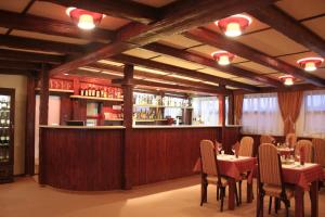 a restaurant with tables and chairs and a bar at Hotel Kormorán in Šamorín