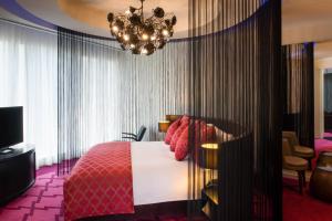 a hotel room with a bed and a chandelier at W Doha in Doha