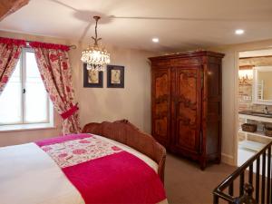 ムルソーにあるChez Hall le Coinのベッドルーム1室(ベッド1台付)、木製キャビネットが備わります。