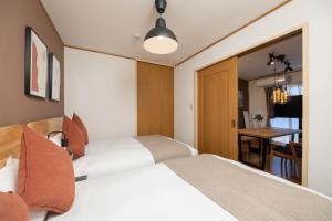 una camera d'albergo con due letti e un tavolo di Maison Raffine ad Osaka Altre 51 foto