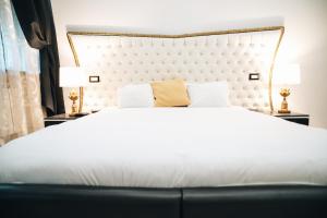 una camera con un grande letto bianco e due lampade di Escape Suite Guest House - Ca Domus Collection a Roma
