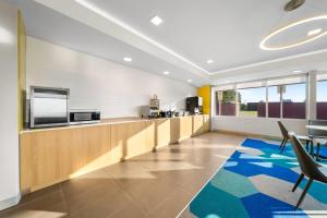 プラットヴィルにあるMicrotel Inn & Suites by Wyndham Prattville Montgomeryのテレビと椅子が置かれたカウンターのあるオフィスロビー