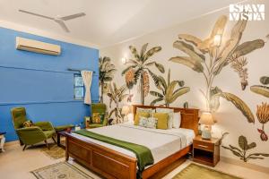 a bedroom with a bed and a blue wall at StayVista at Villa Nimaya with Lawn & Pool in Saligao