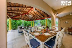 a dining room with a wooden table and chairs at StayVista at Villa Nimaya with Lawn & Pool in Saligao