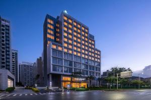 珠海市にあるDays Hotel by Wyndham Zhuhai Jinwanの街中の明かりが灯っている高層ビル