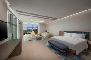 珠海市にあるDays Hotel by Wyndham Zhuhai Jinwanのベッドとテレビがあるホテルの部屋 +10枚の写真