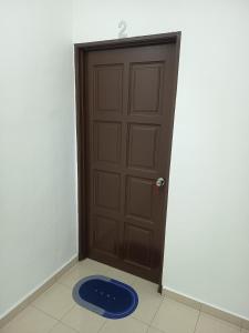 une porte avec un tapis bleu devant elle dans l'établissement Harmoni Homestay R2 Wakaf Tapai ECRL KT Station, à Kuala Terengganu