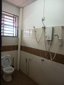 une salle de bain avec toilettes et douche dans l'établissement Harmoni Homestay R2 Wakaf Tapai ECRL KT Station, à Kuala Terengganu