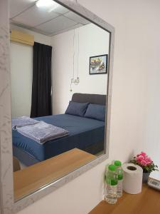 - un miroir reflétant un lit dans une chambre dans l'établissement Harmoni Homestay R2 Wakaf Tapai ECRL KT Station, à Kuala Terengganu