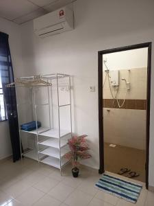une salle de bain avec une douche et une étagère et une plante dans l'établissement Harmoni Homestay R2 Wakaf Tapai ECRL KT Station, à Kuala Terengganu 10 autres photos