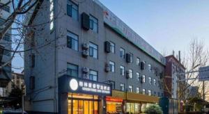 a building with a sign on the side of it at GreenTree Inn Anhui Bozhou West Guangming Road Tangwang Avenue Shall Hotel in Bozhou