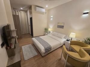 a bedroom with a large bed and a chair at Garden Centre Resort's in Atlāba