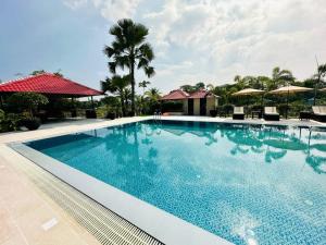 a pool at a resort with palm trees and umbrellas at Garden Centre Resort's in Atlāba +33 photos