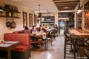 a group of people sitting at tables in a restaurant at Casa Rubin in Dumaguete