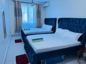 a hotel room with two beds and a couch at Gianas stays Nyali in Mombasa +17 photos