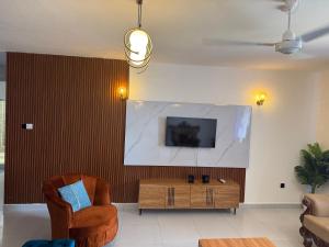 a living room with a flat screen tv on a wall at Gianas stays Nyali in Mombasa