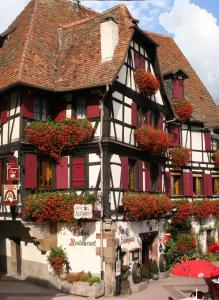 een zwart-wit gebouw met bloembakken erop bij Hôtel Restaurant Zum Schnogaloch in Obernai