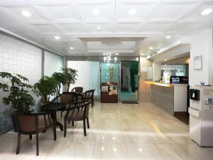 a dining room with a table and chairs and a kitchen at Hotel Casa Suwon in Suwon
