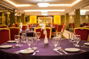 a purple table with glasses and a vase with flowers at Hotel Castle Salam in Khulna +70 photos