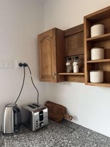 a kitchen with a toaster and a microwave on a counter at Swansea Coastal Retreat Near Sea & IGA in Swansea