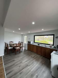 a kitchen and dining room with a table and a window at Swansea Coastal Retreat Near Sea & IGA in Swansea