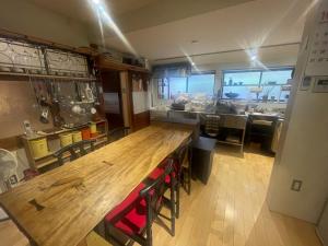 a large kitchen with a large wooden table and chairs at 和紙にまみれるワラビーランド in Mino