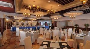 a banquet hall with white tables and chairs and chandeliers at New century Manju Select Hotel Hongqiao Hub National Exhibition Center in Shanghai