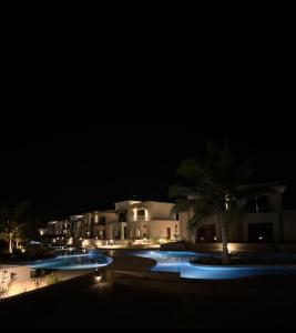 a night view of a resort with two swimming pools at Hawana Salalah in Salalah